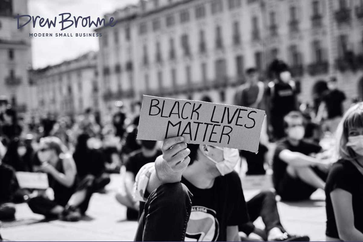 demonstrators sitting holding signs 'Black Lives Matter'