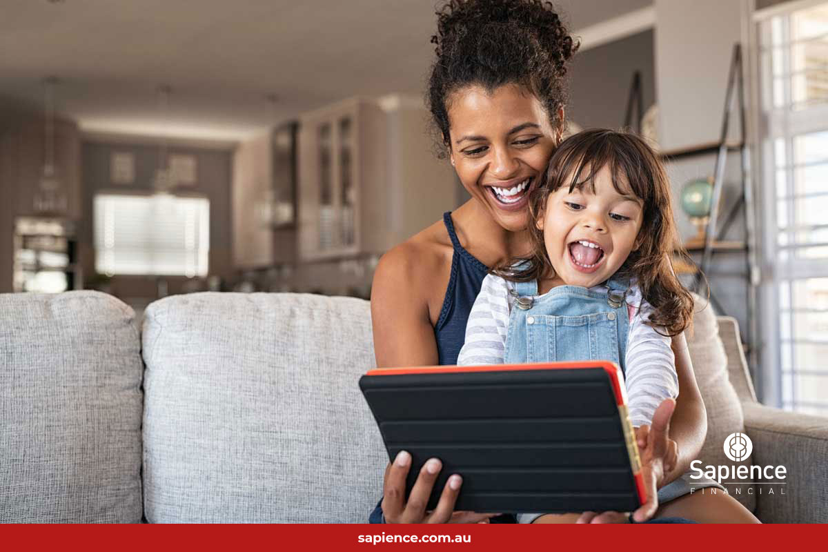 mother and young daughter laughing at content displaying on a tablet device