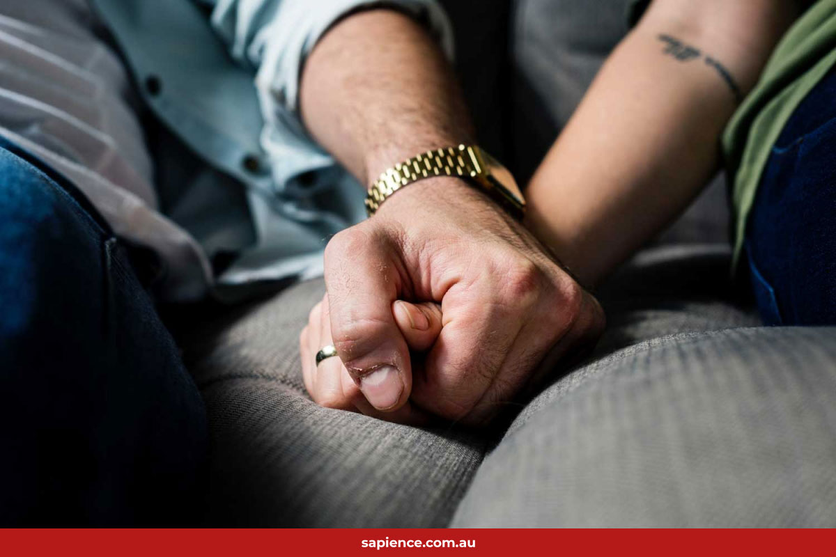 couple holding hands on sofa