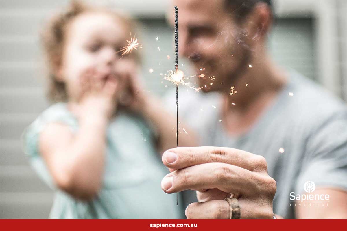 father holding sparkler and his young daughter