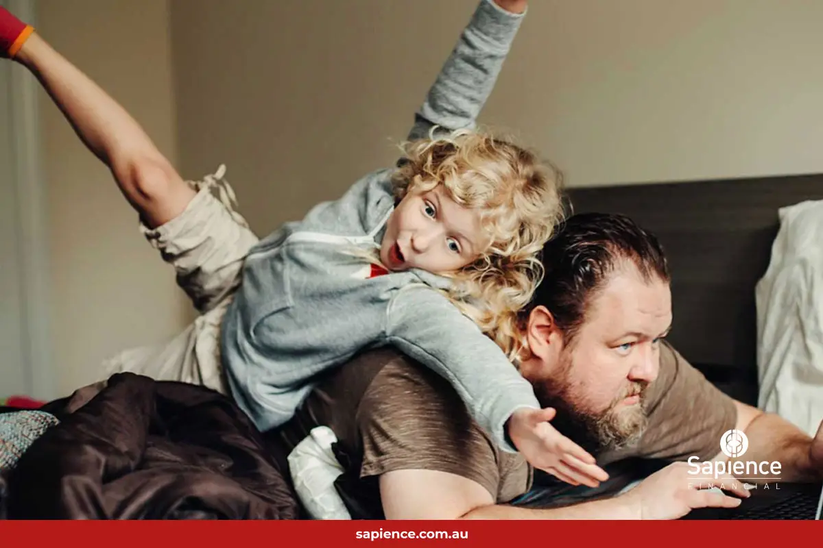 daughter jumping on father while he is working