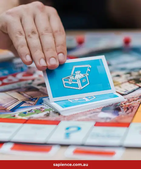 person selecting the unknown Community Chest card in the board game Monopoly 