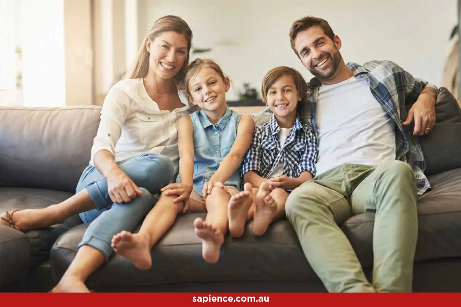happy young blending family sitting on the couch